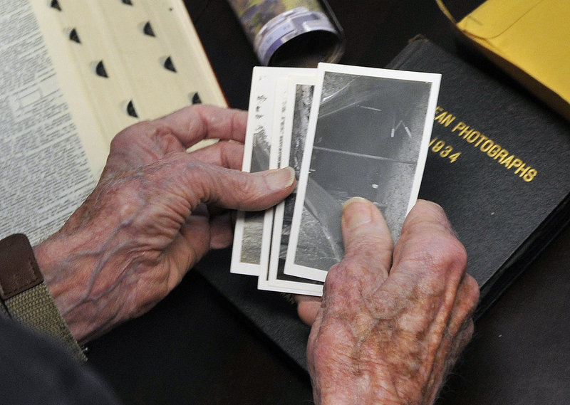 Morse holds photos from his time of military service during World War II.