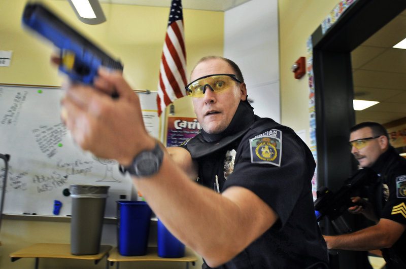 Gorham Police Officer Mike Brown clears a room at the Westbrook Middle School Tuesday, during live-fire training. Officers faced mock hostage situations and fired paintballs for ammunition.