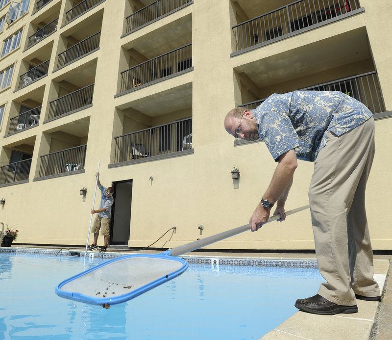 Reporter Ray Routhier works with Adam Hawkes of Meech Property Management as they clean a pool at a condo.