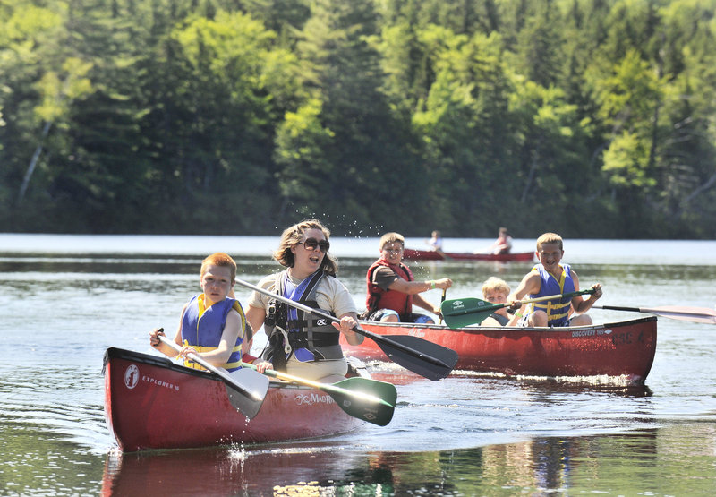 Erin White, waterfront director at Camp Susan Curtis, leads campers in a boating class on Trout Lake on Friday. Campers participate in traditional camp activities as well as learning valuable life skills.