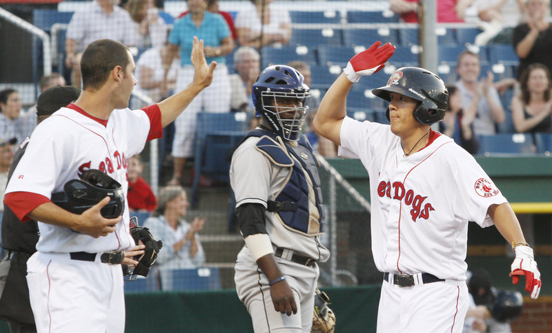 Chi-Hsien Chiang, right, is met by Alex Hassan after hitting a two-run homer in the fourth inning for the Sea Dogs.