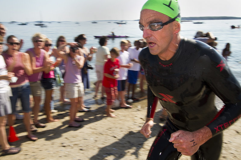 Scott Yeomans, 47, reaches the beach as the first out of the water to win the Peaks to Portland. “You have to stay focused on your stroke and keep going,” he said.