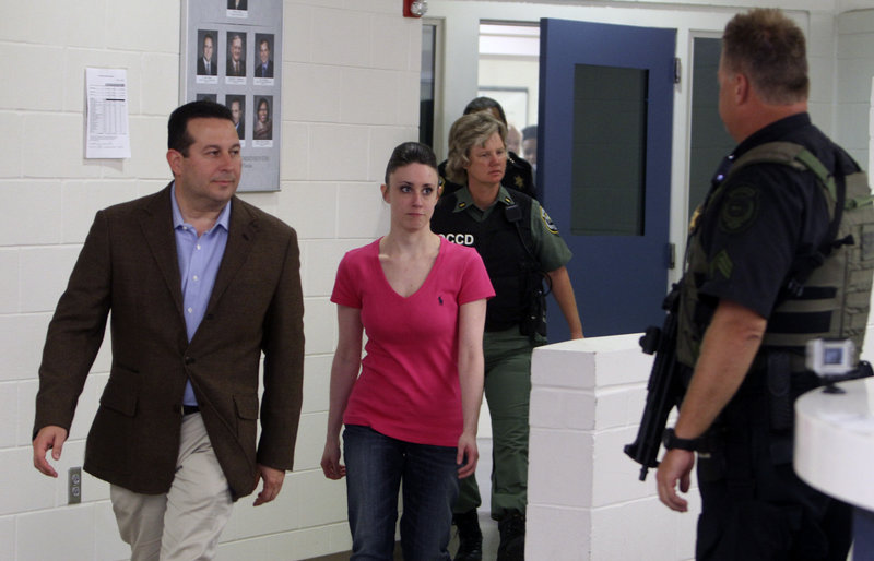 Casey Anthony, center, walks with her attorney, Jose Baez, left, out of the Orange County (Fla.) Jail, bound for an undisclosed site.