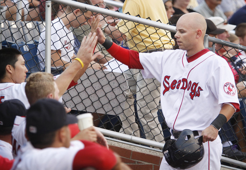 Ryan Khoury of the Sea Dogs gets back to the dugout after scoring in the first inning on a double by Will Middlebrooks at Hadlock Field Monday night. The Sea Dogs won 7-4 by scoring five times in the seventh inning.