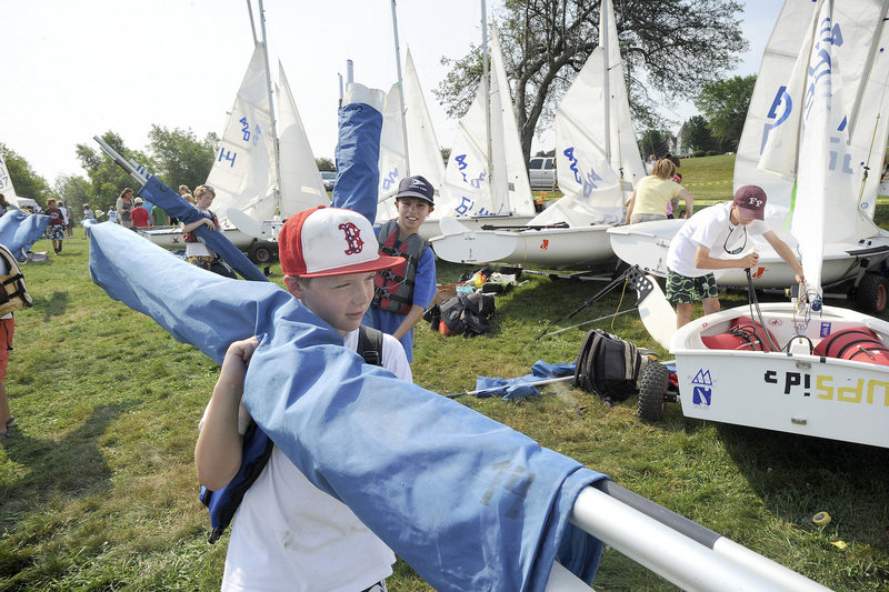 Ten-year-old Connor Reilly of Medfield, Mass., works to assemble his Optimist sailboat. The regatta gives new racers a taste of competition and is also a great venue for older racers, said Sarah Helming, director of programs at SailMaine.