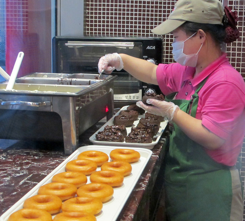 A Krispy Kreme worker prepares the day’s offerings in Shanghai.