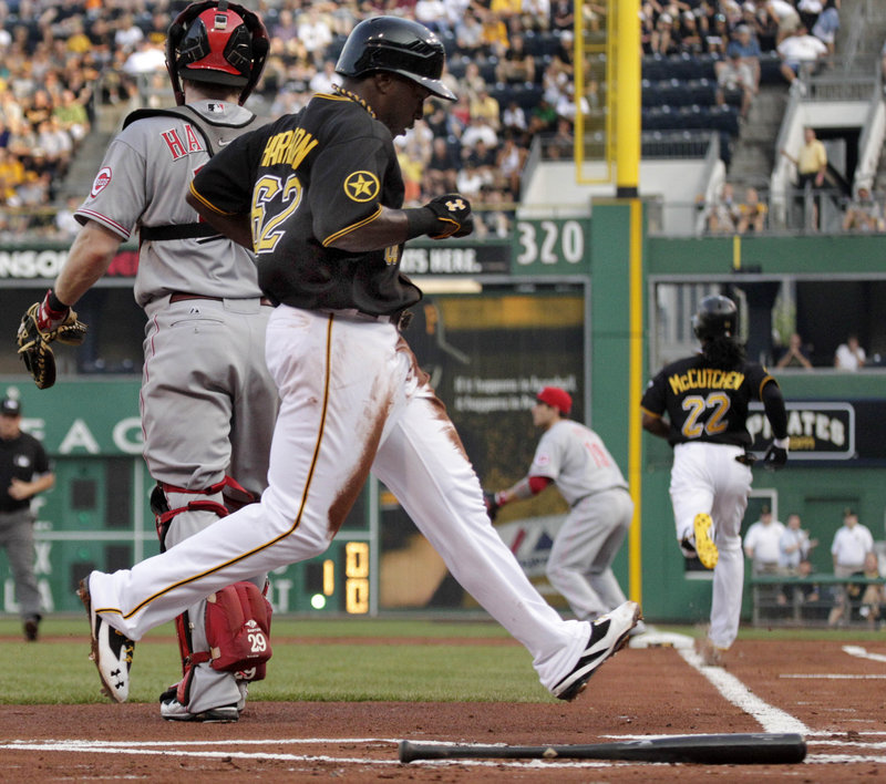 Josh Harrison of the Pirates scores on Andrew McCutchen’s grounder Tuesday night in the 1-0 victory against the Reds.