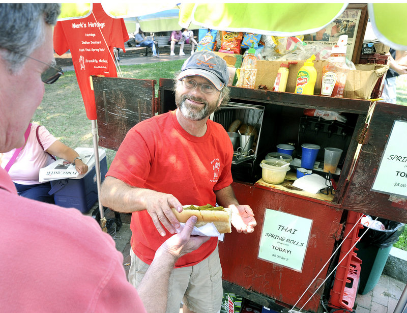Mark Gatti sells hot dogs and sausages at Tommy’s Park in Portland on Wednesday. Gatti bought his first food cart at 23, but his three-year plan is now going on 28 years.