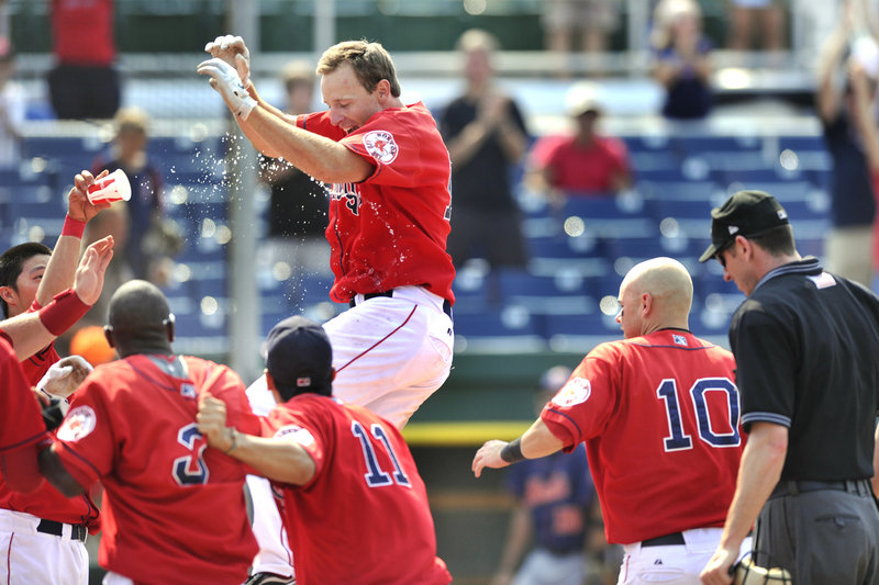 Mitch Dening is welcomed by his Portland Sea Dogs teammates Wednesday after hitting the first walk-off homer of his Double-A career, producing a 10-9 victory against the Binghamton Mets at Hadlock Field.