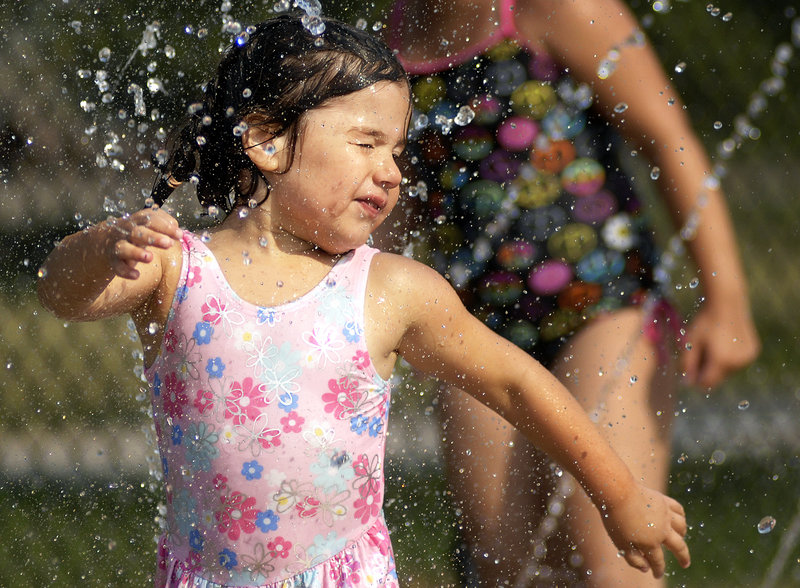 Sofia Andrade, 3, of South Portland cools off in the splash pad at the Kiwanis community swimming pool in Portland on Wednesday. The weather forecast suggests the pool will have plenty of visitors in the next few days.