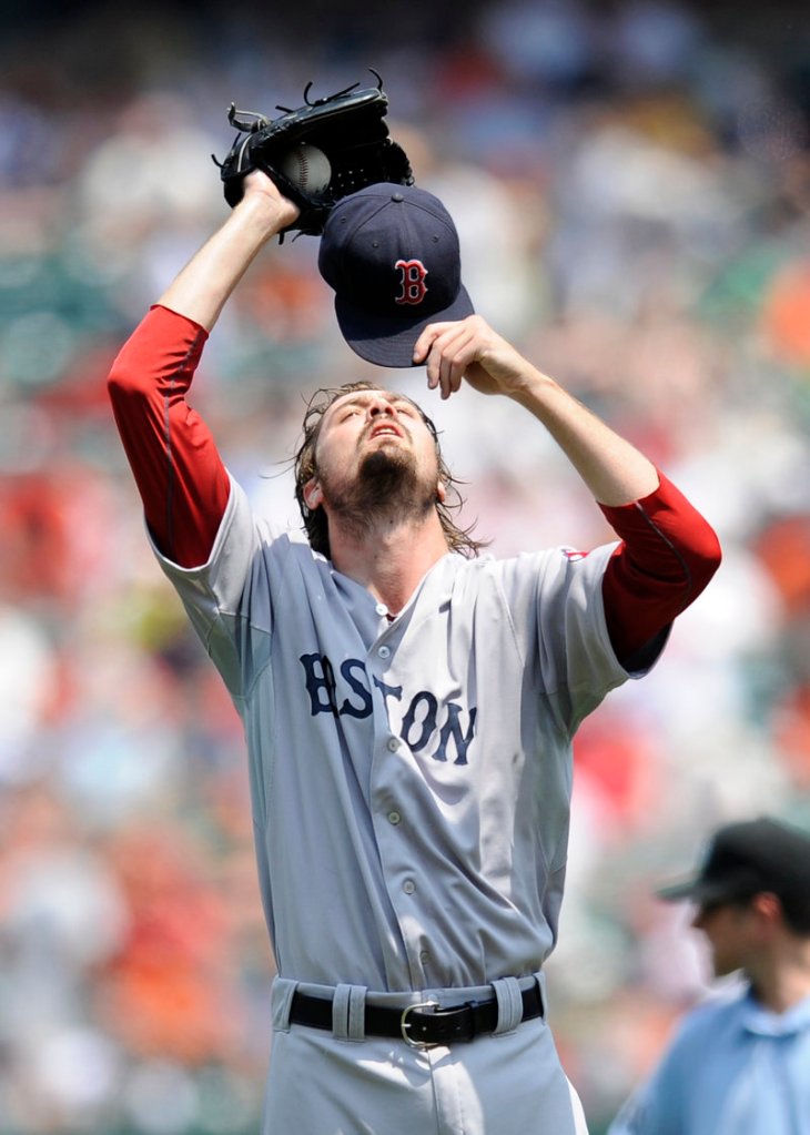 Andrew Miller adjusts his cap during a game against the Orioles on Monday that started in 95-degree heat. Boston beat Baltimore, 4-0.