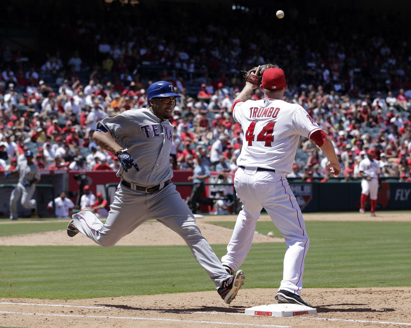Nelson Cruz of the Texas Rangers beats out an infield single Thursday as Mark Trumbo of the Los Angeles Angels awaits the throw during the sixth inning. The Angels won, 1-0.