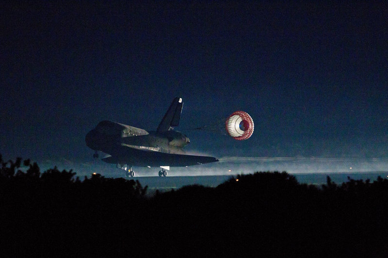 The drag chute is deployed as the space shuttle Atlantis lands at the Kennedy Space Center in Cape Canaveral, Fla., completing the final mission of the NASA shuttle program. Atlantis and its four astronauts glided to a safe landing in near-darkness early Thursday.