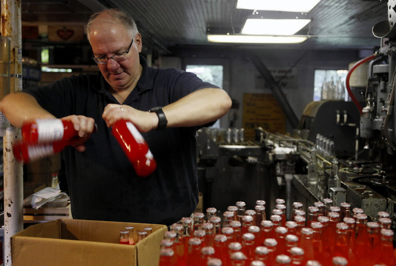 Rob Metz of New Britain, Conn., shakes water off bottles of fruit punch soda at Avery Soda in New Britain. The company has existed for more than 100 years and continues to make and bottle soda in-house.