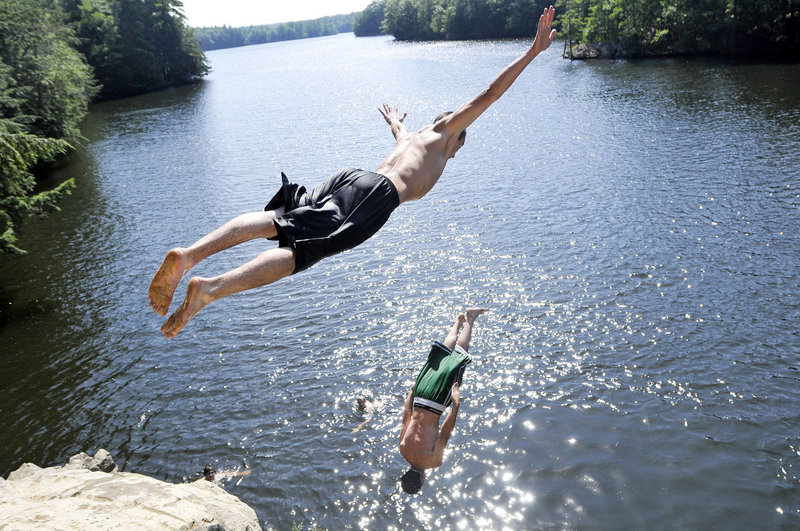 Matt LeBlanc of Dayton dives as Matt Jervis of Lyman does a backflip into the Saco River from a cliff at Pleasant Point Park in Buxton on Friday.