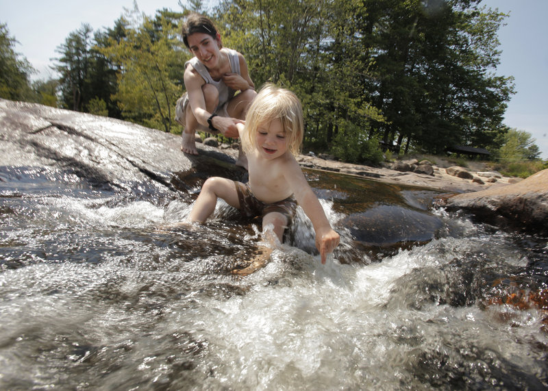 Two-year-old Alanah Allen of Standish gets a break from the heat Friday by playing in the Saco River in Limington with her mom, Cary Leavitt.
