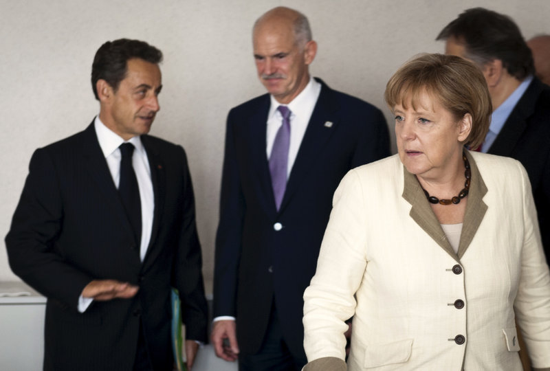 German Chancellor Angela Merkel, right, is seen after a meeting with Greek Prime Minister Giorgos Papandreou, center, and French President Nicolas Sarkozy prior to a summit on Europe’s financial crisis in Brussels on Thursday.