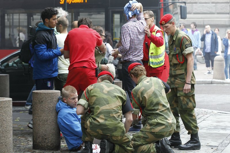 Wounded people are treated in the street in Oslo on Friday after an explosion tore open buildings including the Norwegian prime minister’s office. A second related attack – a rampage at a youth summer camp – claimed more victims, for a combined death toll of at least 87.