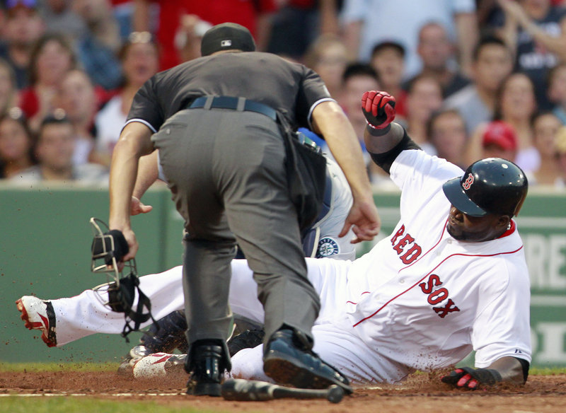 David Ortiz of the Red Sox is out at home plate on a throw from Seattle’s Franklin Gutierrez after a fly out by Jason Varitek in the second inning Saturday night at Fenway Park.