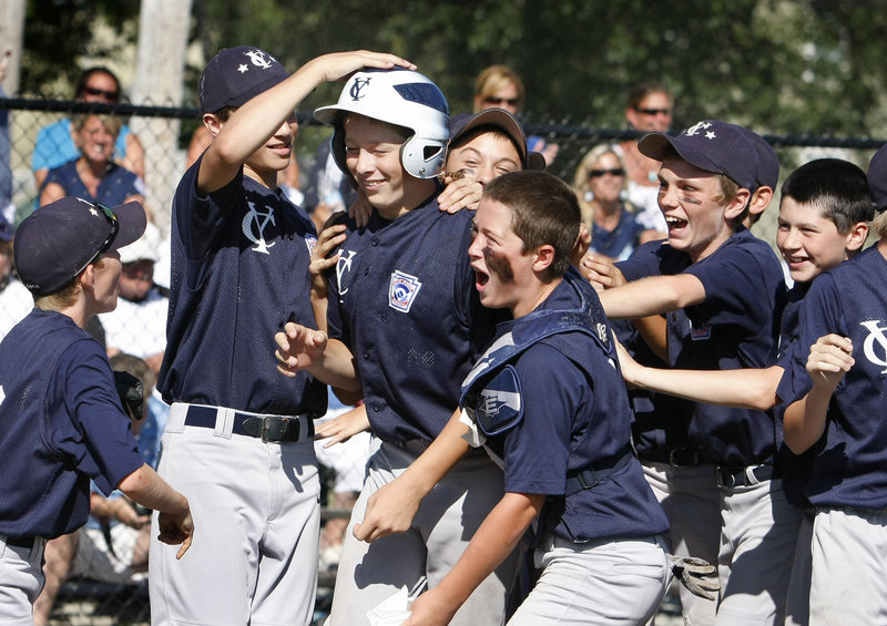 Luke Klenda, third from left, celebrates with teammates after hitting a solo home run in the second inning Sunday against York in the Little League state tournament for 11 and 12 year olds. Yarmouth went on to beat York, 2-1.