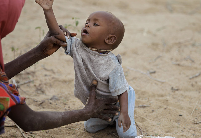 A child is picked up by his mother in the border town of Dhobley, Somalia, on Sunday. World Food Program’s Executive Director Josette Sheeran said new funding is critical to fight the three-pronged catastrophe of drought, conflict and high food prices.