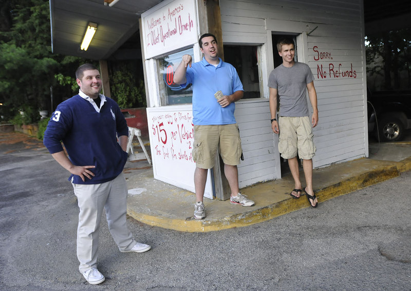 Ry Russell, Tyler Wells and Patric Brophy, University of Southern Maine marketing students and managers of the Saco Drive-In, talk with customers at the entrance Friday. “You can’t beat it as a family coming here,” Wells said.