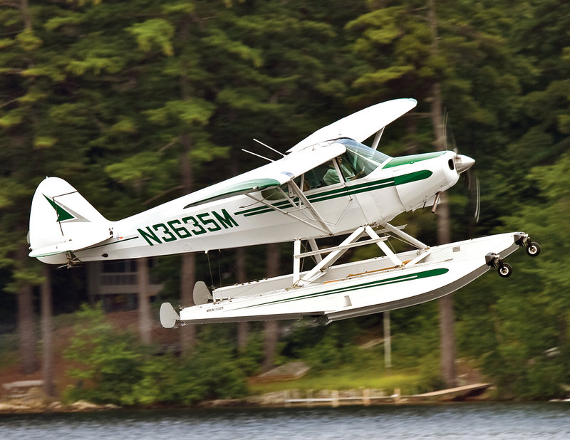 It is common to see seaplanes above the Lakes Region at this time of year. Here, Mary Build, who earned her wings in 1991, takes off with her grandkids in a Piper Cub.