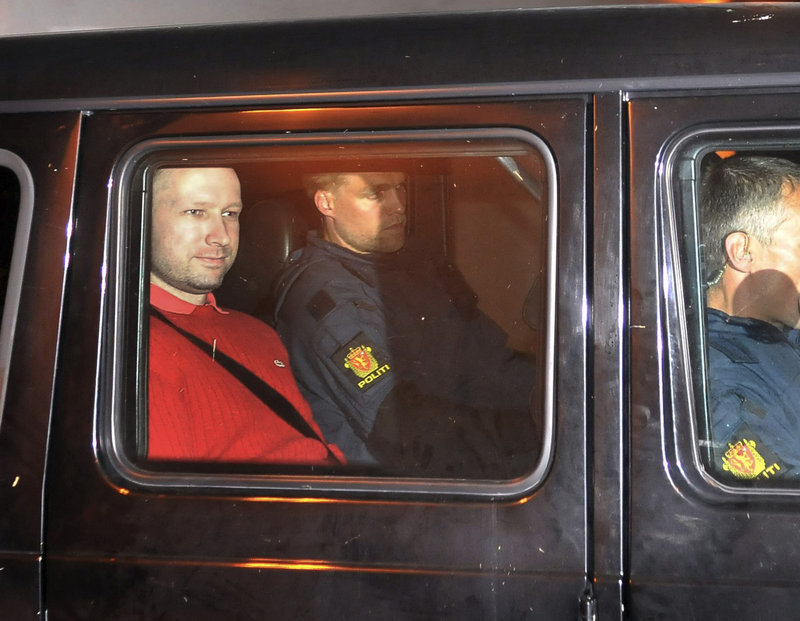Attack suspect Anders Behring Breivik, left, who is wearing a uniform, sits in an armored police vehicle at a courthouse Monday in Oslo.