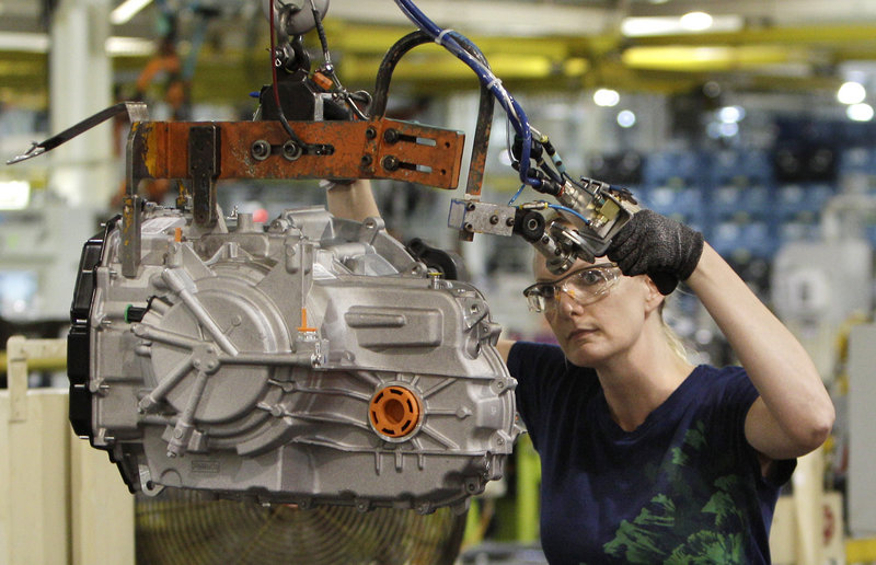 Cheryl Simpson moves a transmission from the assembly line to a pallet at the Ford Van Dyke plant in Sterling Heights, Mich.
