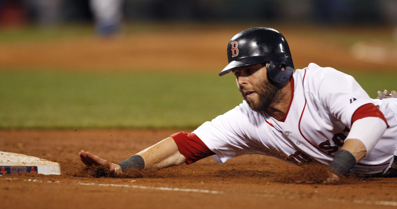 Dustin Pedroia dives safely back to first base on a pickoff attempt by Kansas City in the second inning Monday night at Fenway Park.