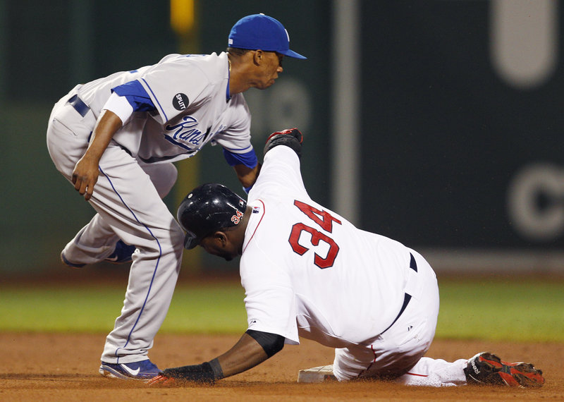 Alcides Escobar, left, makes the tag as David Ortiz is caught trying to steal second base in the fourth inning Monday night in Boston. The start of the game was delayed 2 hours, 21 minutes by a passing rain shower.