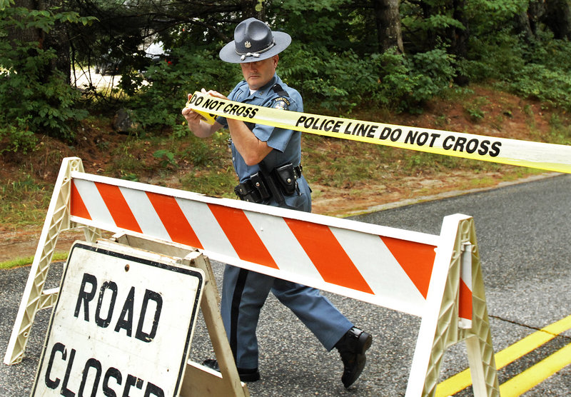 State Trooper Steven Green seals off a part of Bennett Road in New Gloucester while investigators collect shooting evidence Tuesday.