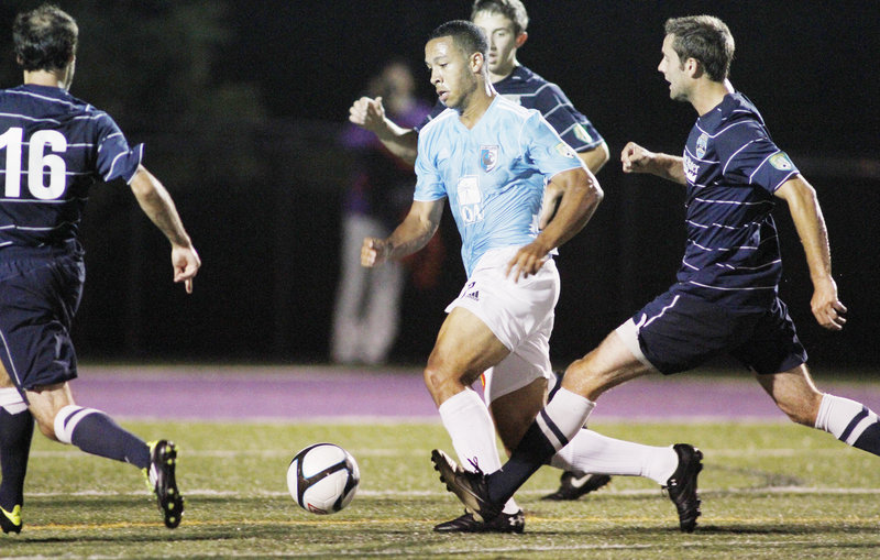 Charlie Rugg of the Portland Phoenix tries to dribble his way through a ring of New Hampshire defenders Tuesday night at Deering High’s Memorial Field. The Phantoms advanced in the PDL playoffs with a 1-0 victory Monday.
