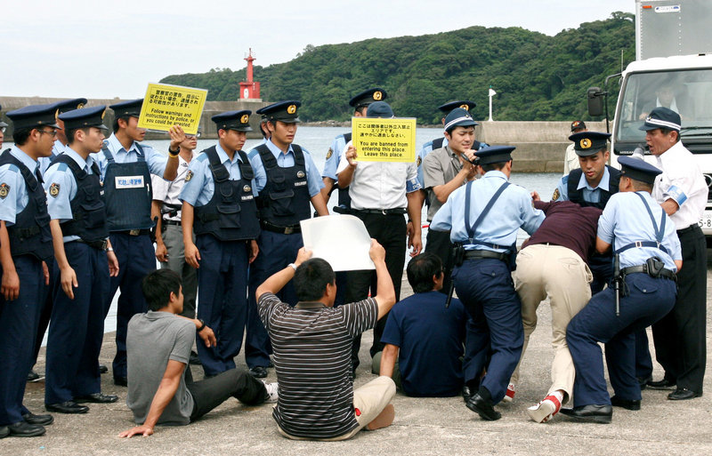Japanese officers block mock protesters during a security drill Wednesday in Taiji, a village under fire for dolphin hunts. About 100 police and coast guard officers gathered in the bay – the scene of an Oscar-winning film “The Cove.”