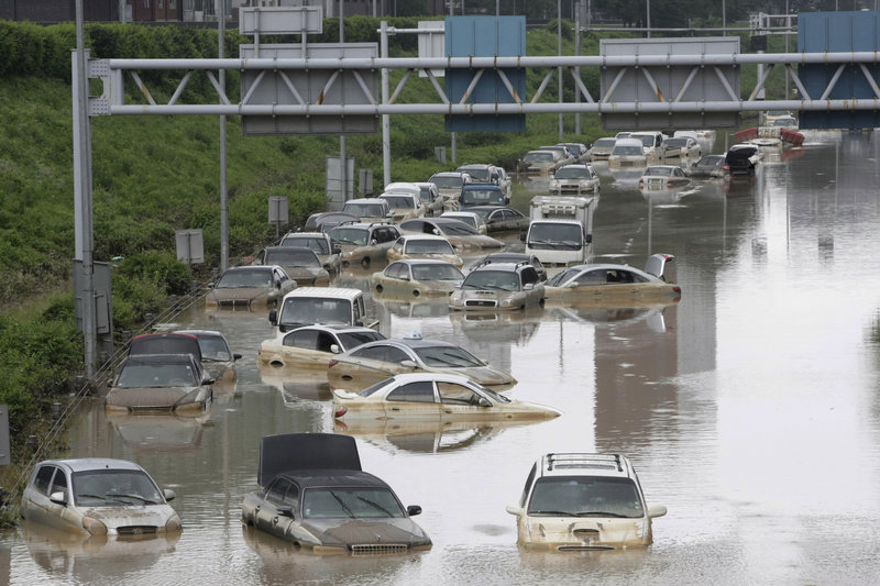 Vehicles are partially submerged after heavy rain in Seoul, South Korea, on Thursday. Rescuers cleared mud to search for survivors after landslides and flooding killed 57 people.