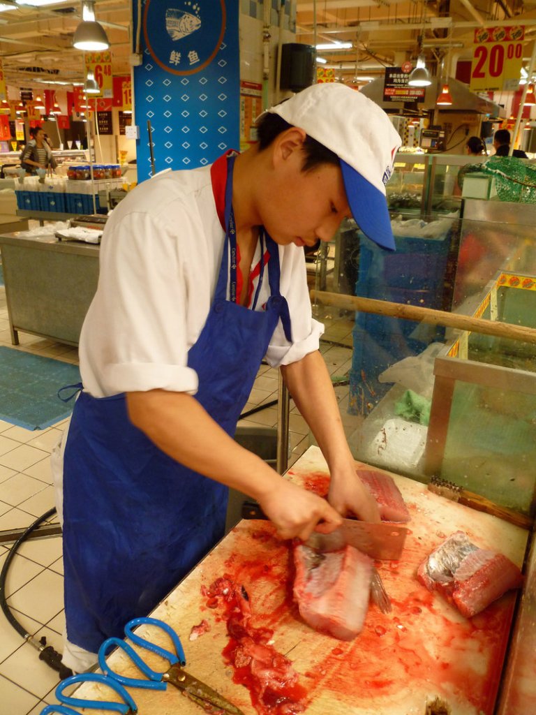 Gui Jin Yu cuts freshly killed carp into fillets at a supermarket in Shanghai, China. Throughout China, shoppers prefer to buy freshwater fish that has been killed minutes before, and they eat it the same day.