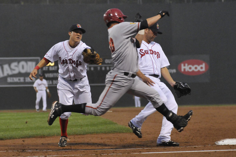 Sea Dogs first baseman Jon Hee, left, attempts to reach Altoona's Yunesky Sanchez as pitcher Charlie Haeger pulls up to avoid a collision. Sanchez beat the tag and was safe at first, but Haeger won his debut with the Sea Dogs.