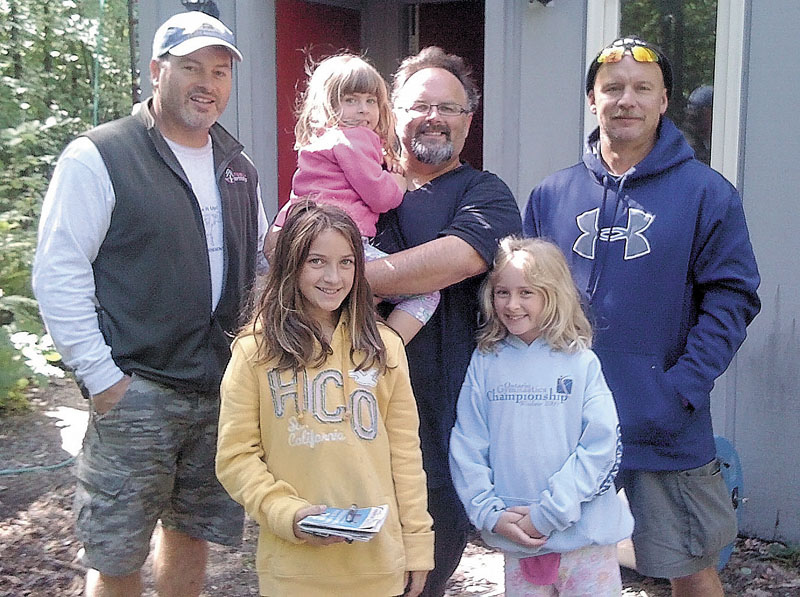 KINDNESS OF STRANGERS: Robert Dupre, left, opened his home in Carrabassett Valley to a family of strangers who were caught by Tropical Storm Irene Sunday. With Dupre is Rob Roberts, holding his daughter Aislinn, and other daughters Fiona, left, and Cait. Also shown is Dupre's friend, Mike McKeon, who also spent the night with the group.