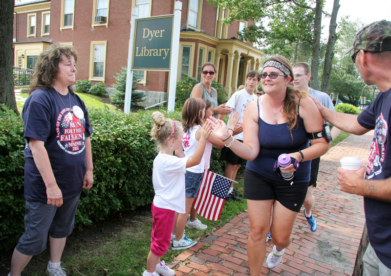 Kathy McDonald of Casco, far left, and her husband, John Williams, far right, are joined by family members today during the Run for the Fallen as they greet runners at the mile-marker in Saco for their son, SGT. Edmund W. McDonald, who was killed in service in Kabul in March 2007.