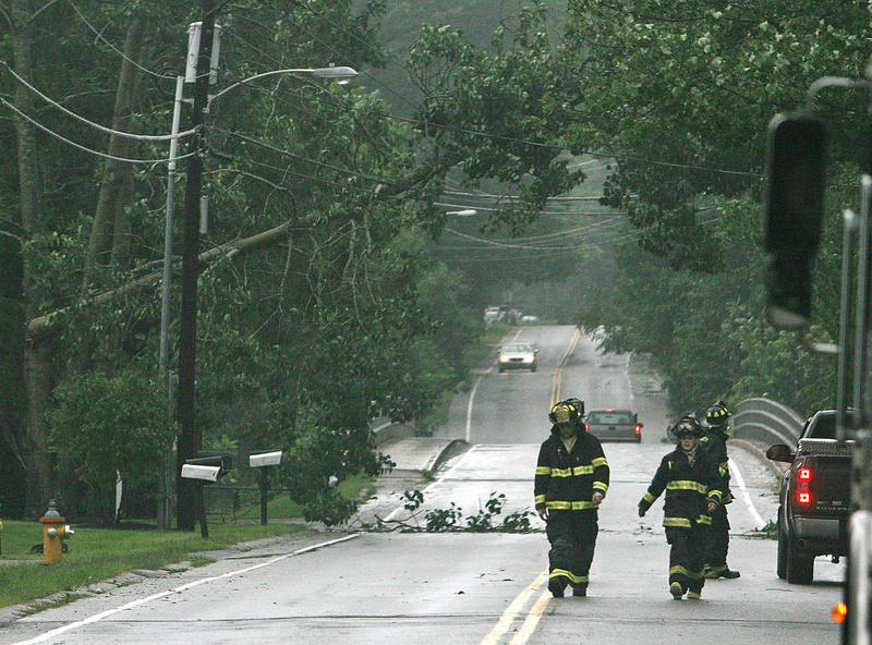 Emergency personnel secure a portion of Leighton Road in Falmouth due to a tree that fell across wires today during Tropical Storm Irene.