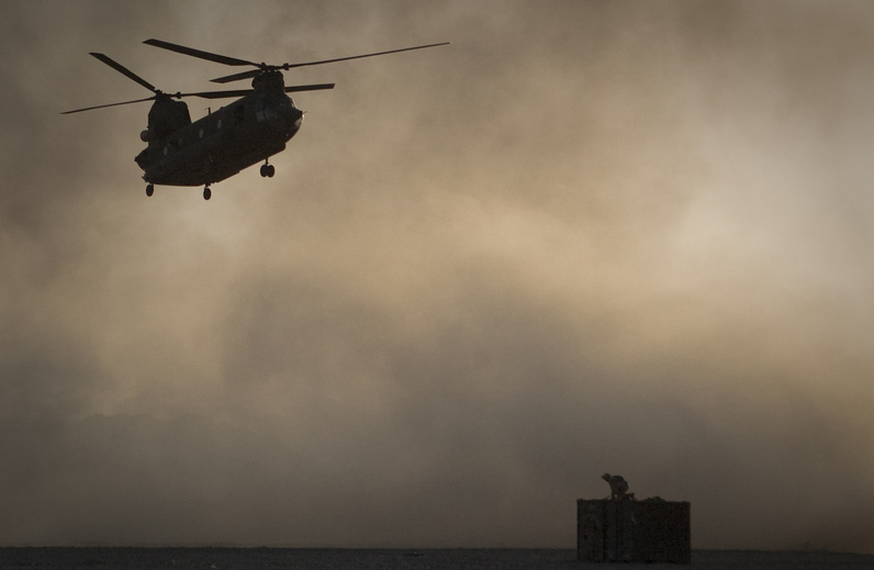 A Marine perched on a container, tries to take cover from the dust as a Chinook helicopter arrives to pick up supplies at Forward Operating Base Edi in the Helmand province of southern Afghanistan, in this June 9 file photo. Afghan President Hamid Karzai said 31 U.S. special forces and seven Afghan soldiers were killed when a helicopter, similar to the one shown, crashed in eastern Wardak province late Friday.
