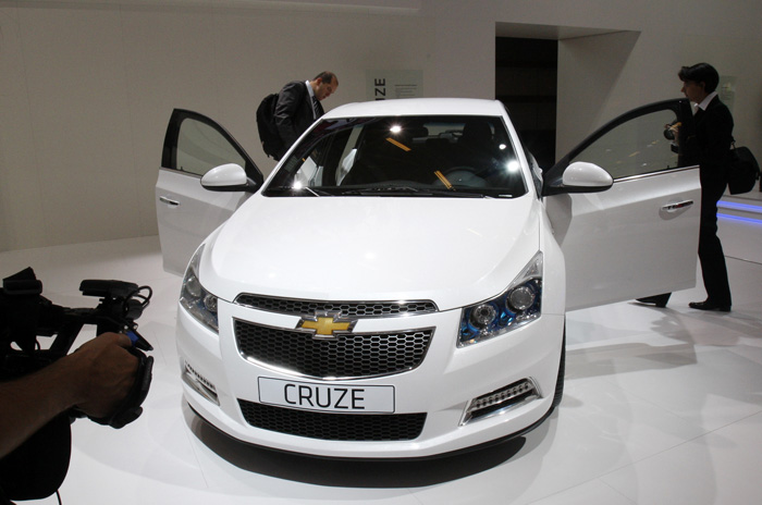 Visitors inspect a 2011 Chevrolet Cruze Hatchback during the Paris Auto Show.