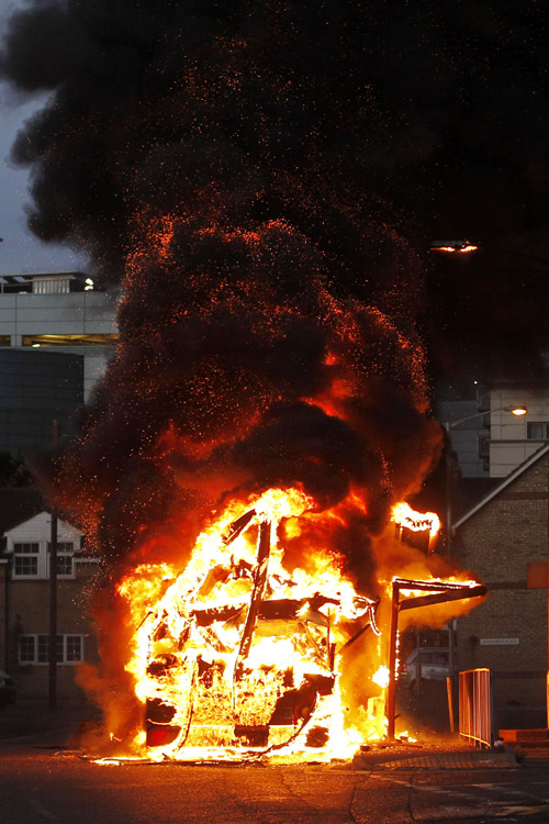 A bus is set on fire as rioters gathered in Croydon, south London, on Monday.