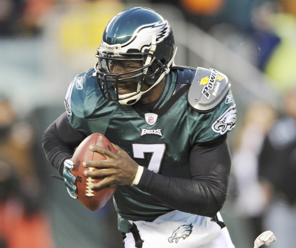 In this Jan. 9, 2011, photo, Philadelphia Eagles quarterback Michael Vick runs from a tackler during the first half of an NFL wild card playoff football game against the Green Bay Packers.