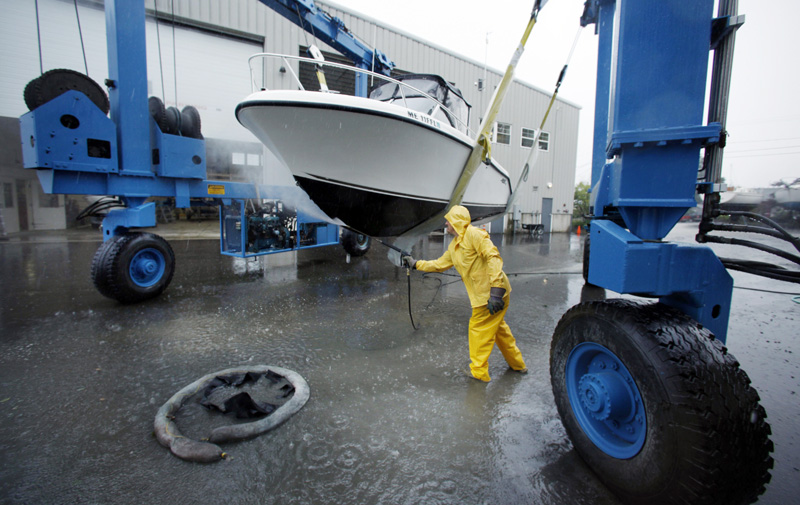 Peter Gavett pressure washes the hull of a pleasure boat he hauled out of the water at Brewer Marine as a precaution before the arrival of Hurricane Irene today in Freeport.