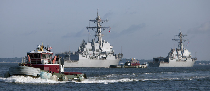 Tugboats help Navy guided missile destroyers the Jason Dunham, left, and the the Winston Churchill, leave the Norfolk Naval Station this morning as Hurricane Irene approaches.