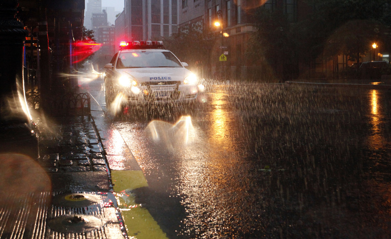 Heavy rain falls as a police car drives in Battery Park City in New York as Hurricane Irene approaches today. Battery Park City and other areas in Lower Manhattan were evacuated in advance of the storm.