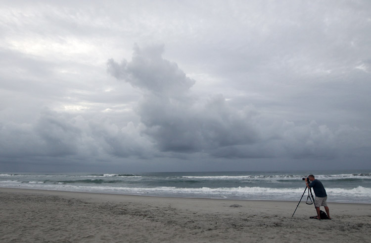 Cash Haggarty, of Washington, takes photos at daybreak in Atlantic Beach, N.C., today. A hurricane watch was issued early today for much of the North Carolina coast. Officials along the East Coast of the United States are calculating what they need to do if Irene becomes the first major hurricane to strike the region in seven years.