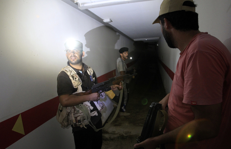 Rebel fighters inspect a tunnel in the bunker under Moammar Gadhafi’s compound in Bab Al-Aziziya in Tripoli, LIbya, on Thursday. Existence of the tunnel system beneath the compound has long been rumored, and rebels discovered an extensive system that had many rooms, multiroom complexes and caches of food.