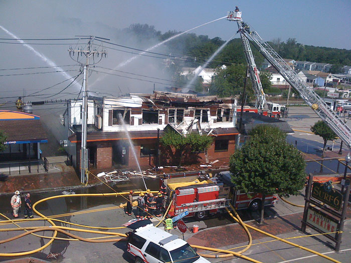 Firefighters on four ladder trucks pour water on the Galaxy night club on East Grand Avenue in Old Orchard Beach late this morning.